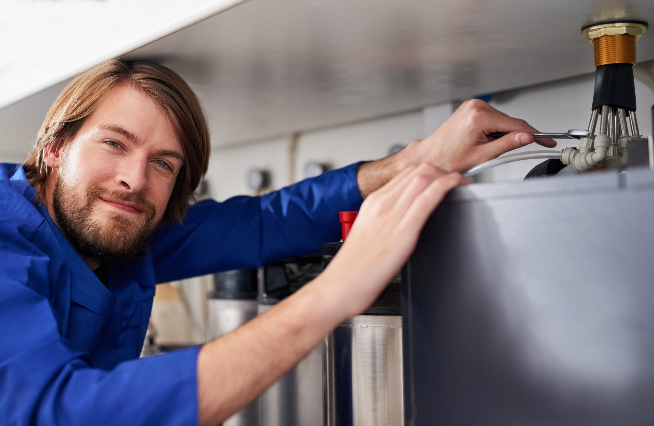 Technician servicing a residential water heater tank in Burbank